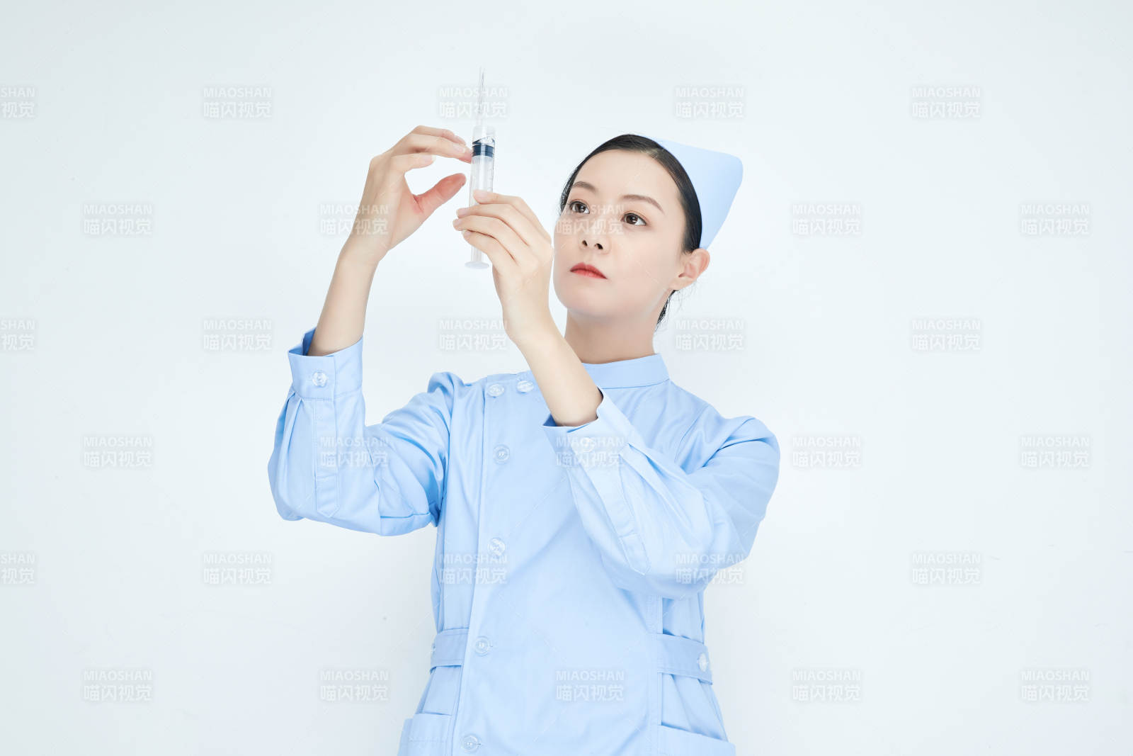 穿护士服戴口罩手执针筒的年轻女护士