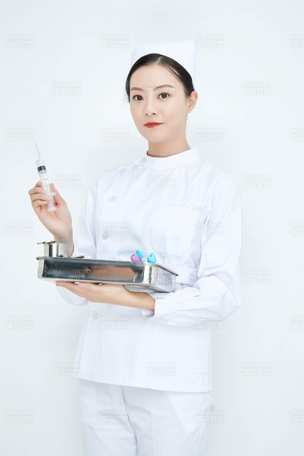 身穿护士服手抱化验托盘的年轻女护士