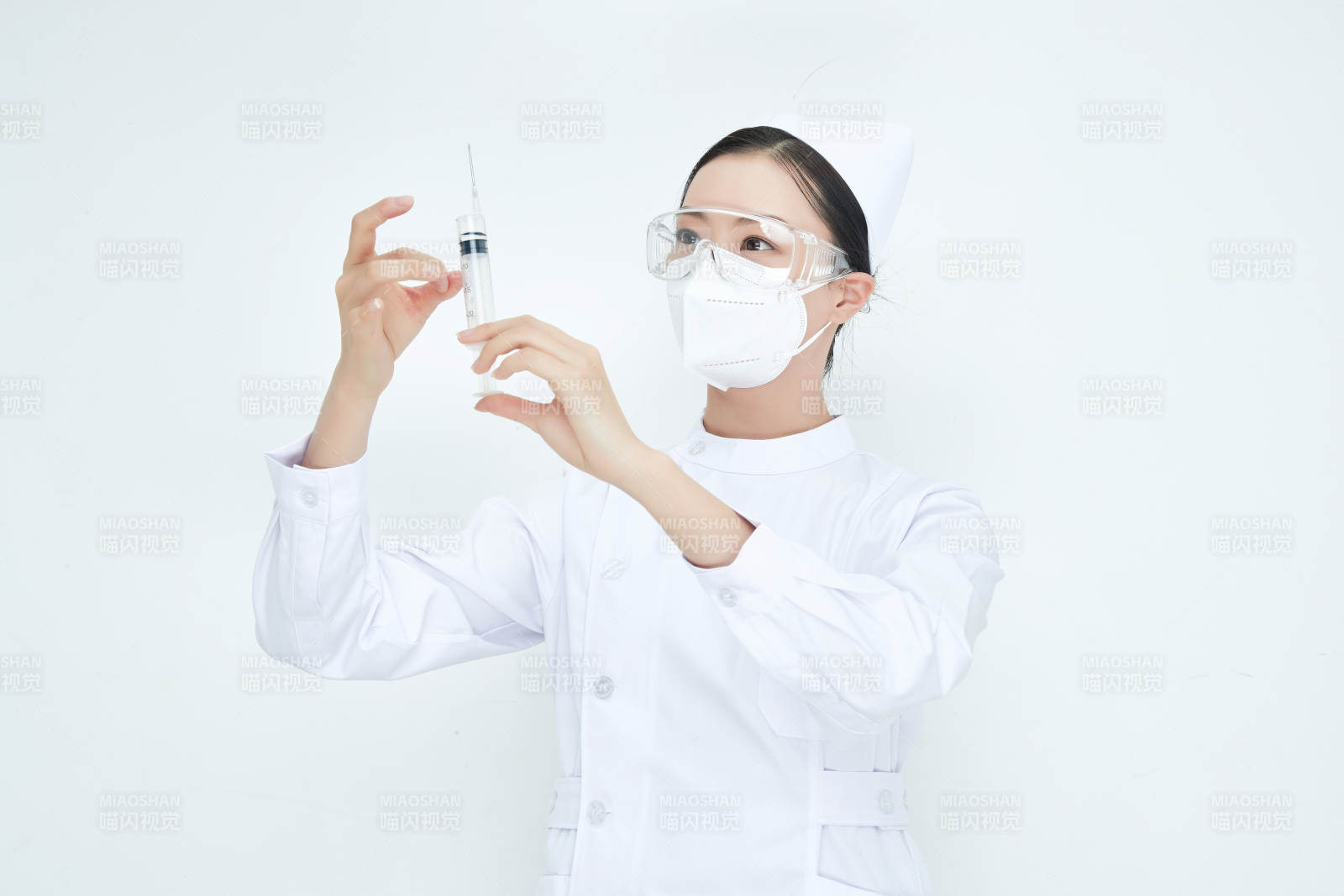 穿护士服戴口罩手执针筒的年轻女护士图片