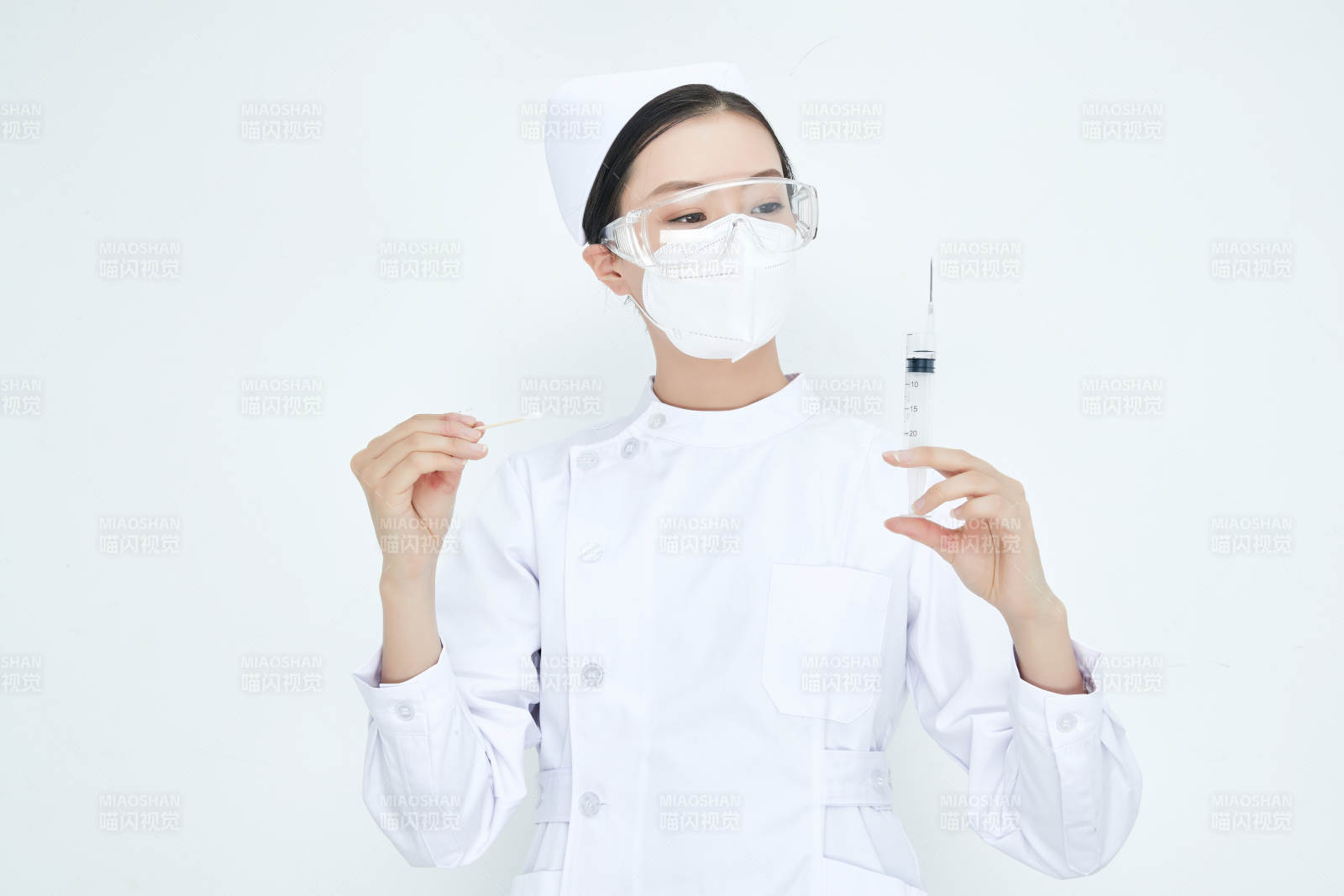 穿护士服戴口罩手执针筒的年轻女护士图片