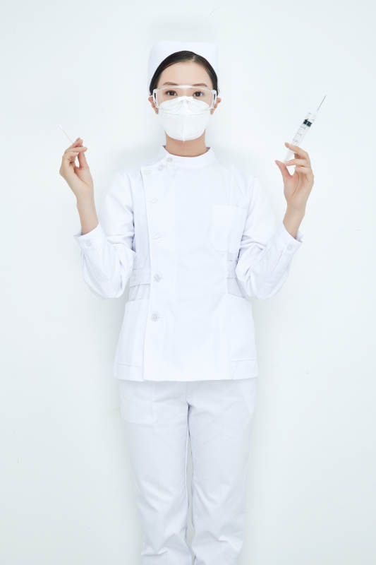 穿护士服戴口罩手执针筒的年轻女护士