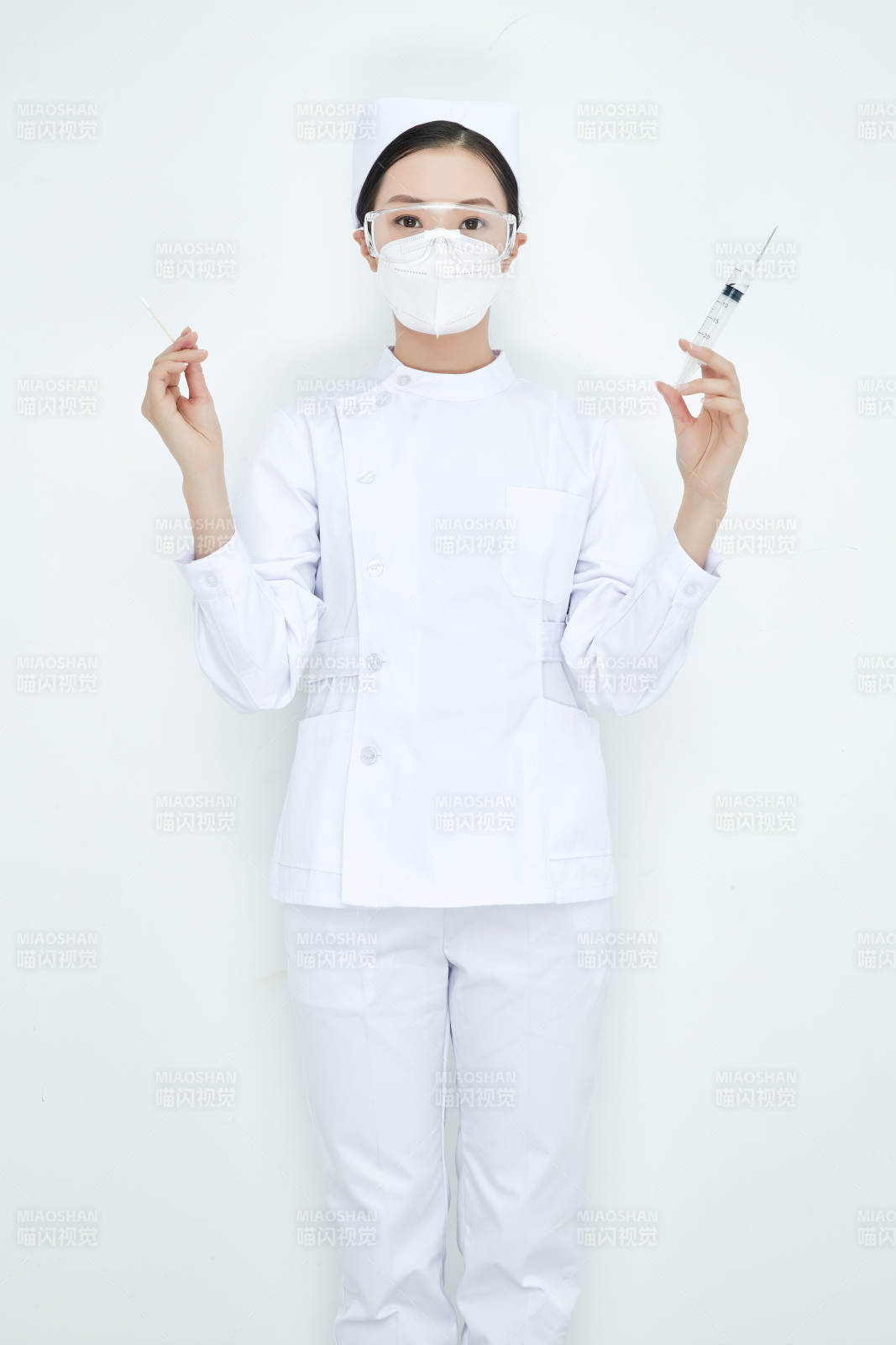 穿护士服戴口罩手执针筒的年轻女护士
