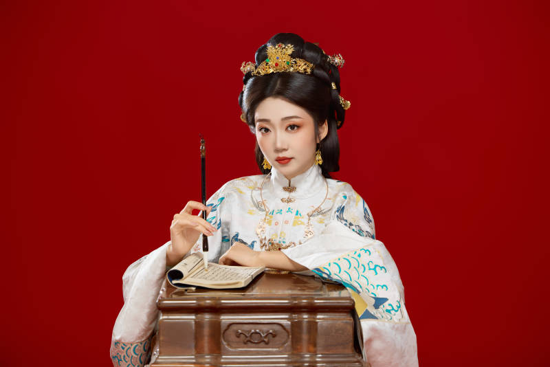 身穿明制汉服在桌前学习传统文化的中国美女