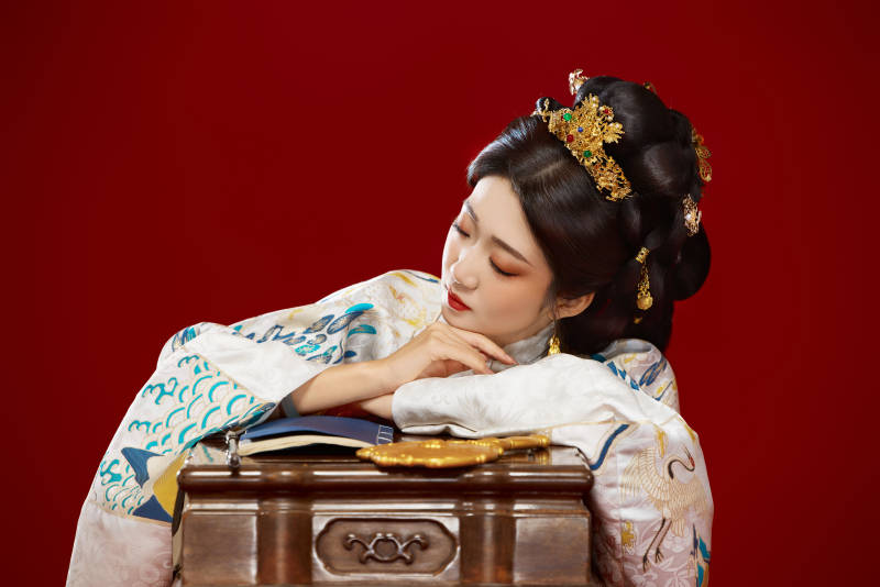 红色背景下穿着中国明朝明制汉服服饰的少女