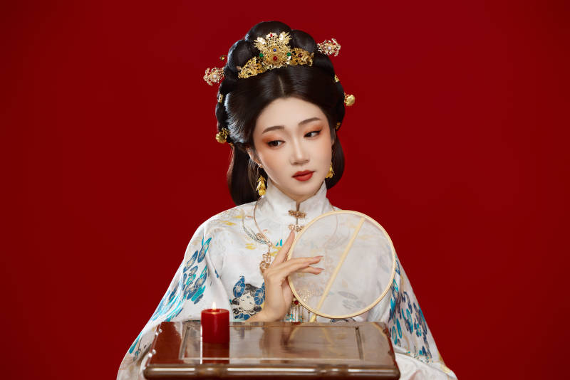 红色背景下穿着中国明朝明制汉服服饰的少女