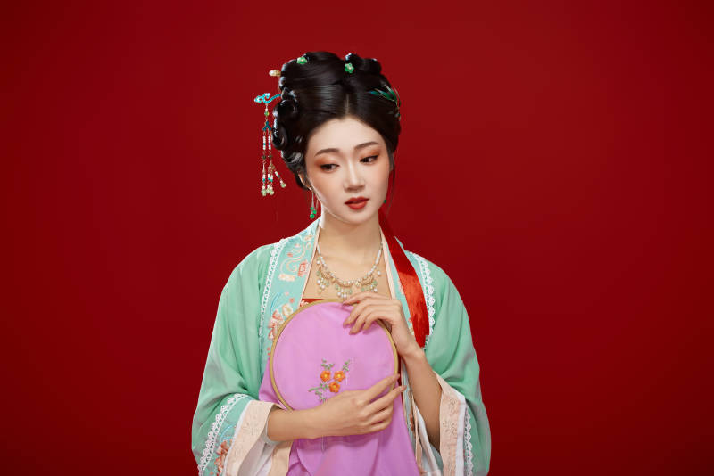 红色背景下穿着南北宋朝汉服的少女