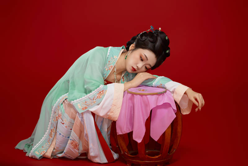 红色背景下穿着南北宋朝汉服的少女