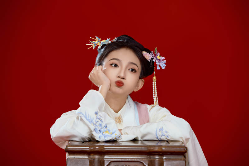 红色背景下穿着中国明朝明制汉服服饰的少女