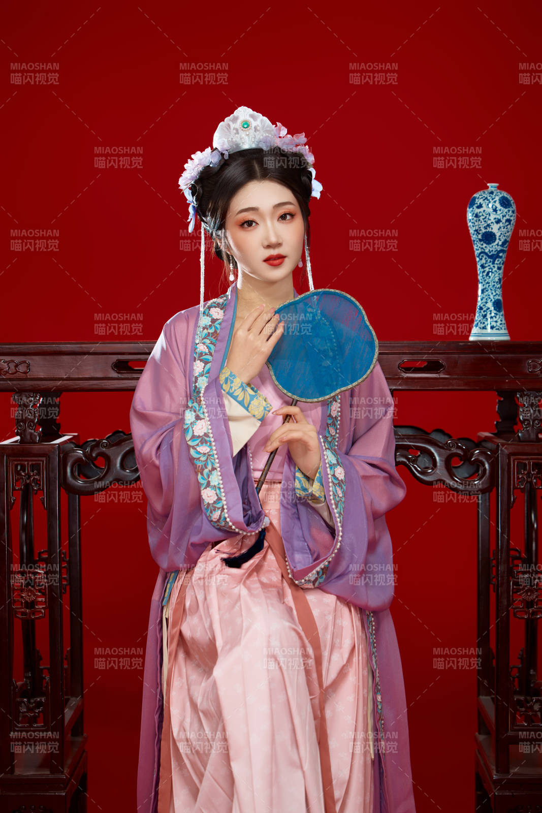 红色背景下身穿中国明朝簪花发饰汉服的美女