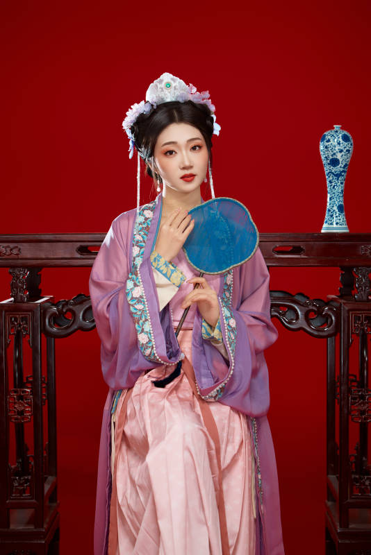 红色背景下身穿中国明朝簪花发饰汉服的美女