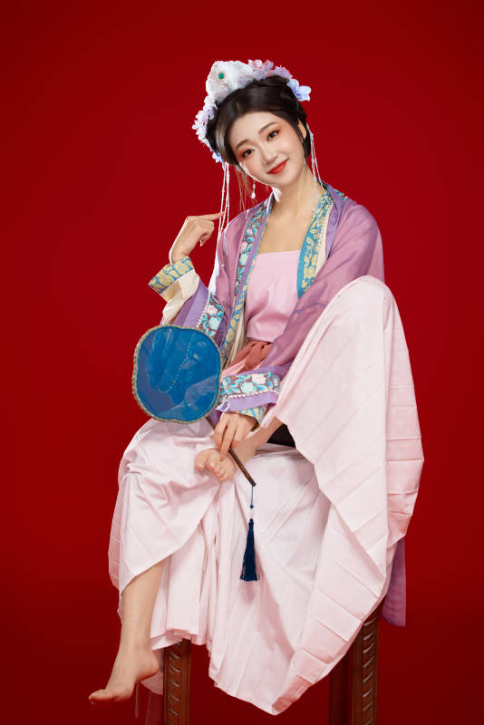 红色背景下身穿中国明朝簪花发饰汉服的美女