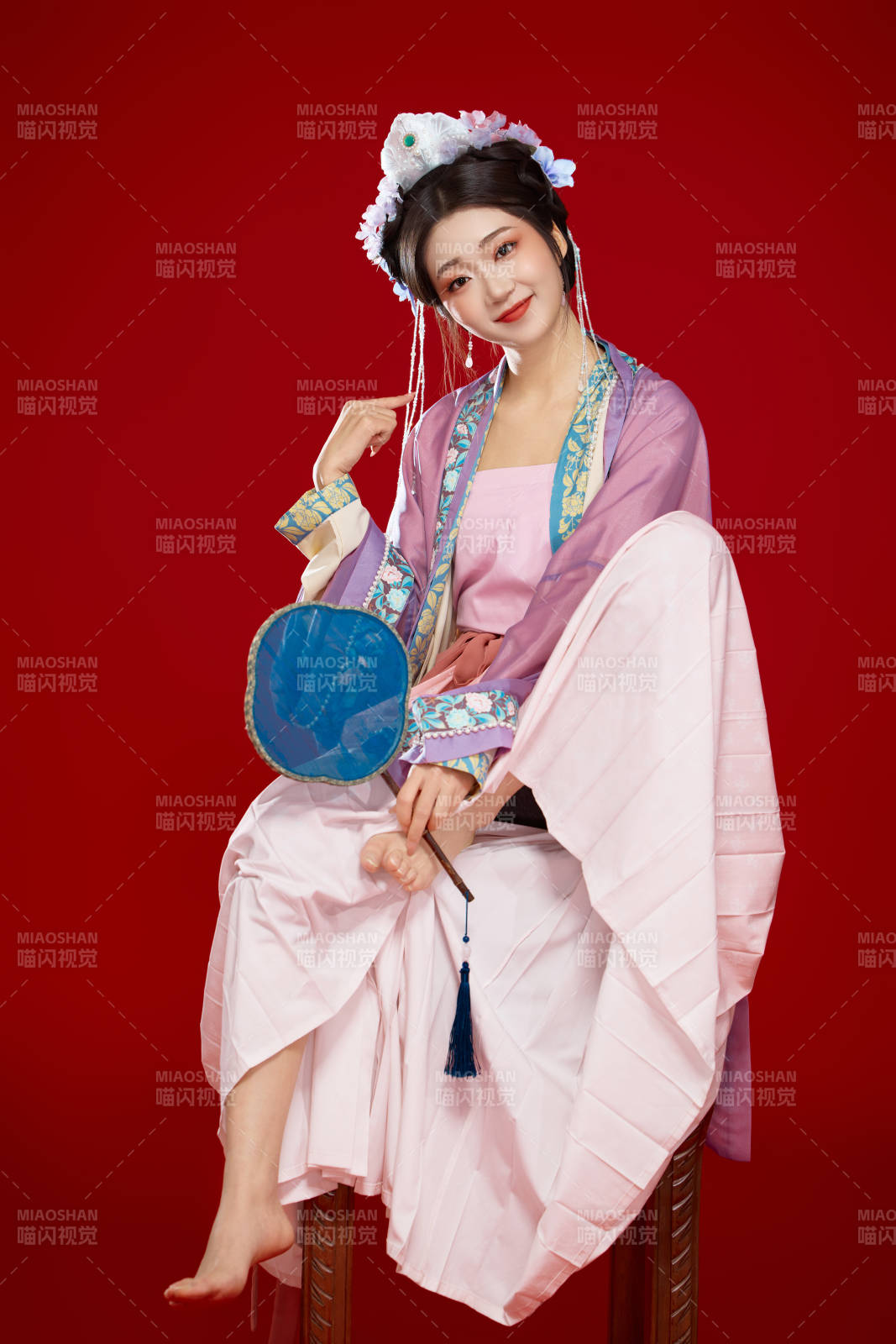 红色背景下身穿中国明朝簪花发饰汉服的美女