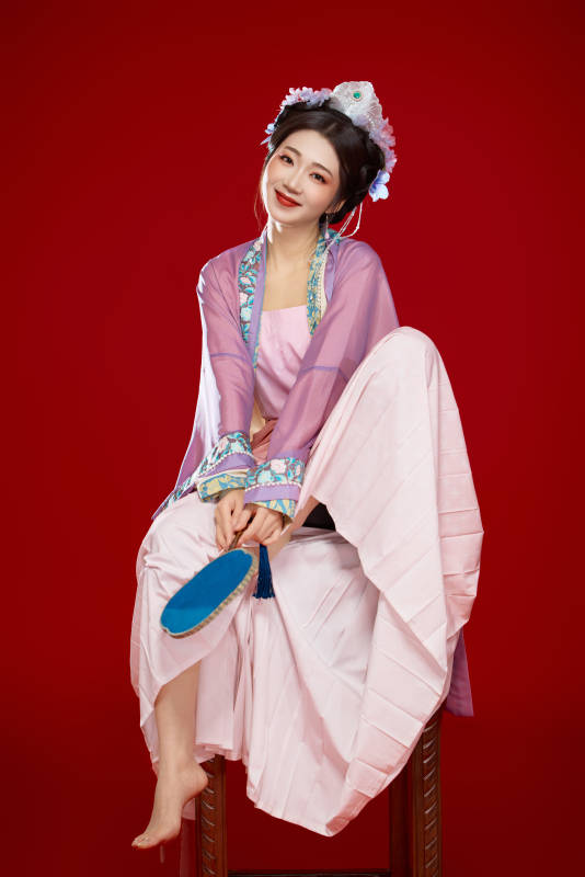 红色背景下身穿中国明朝簪花发饰汉服的美女