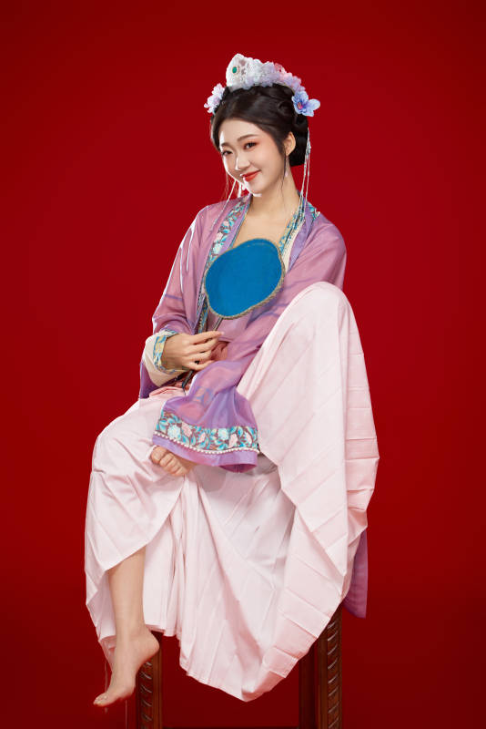 红色背景下身穿中国明朝簪花发饰汉服的美女