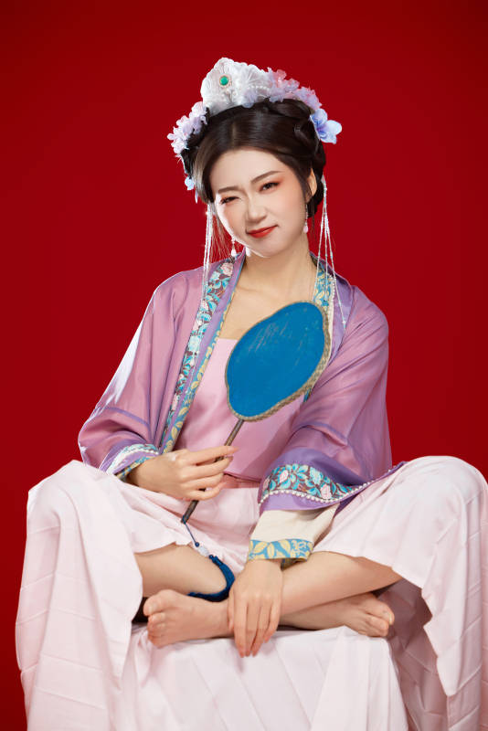 红色背景下身穿中国明朝簪花发饰汉服的美女