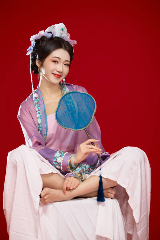 红色背景下身穿中国明朝簪花发饰汉服的美女