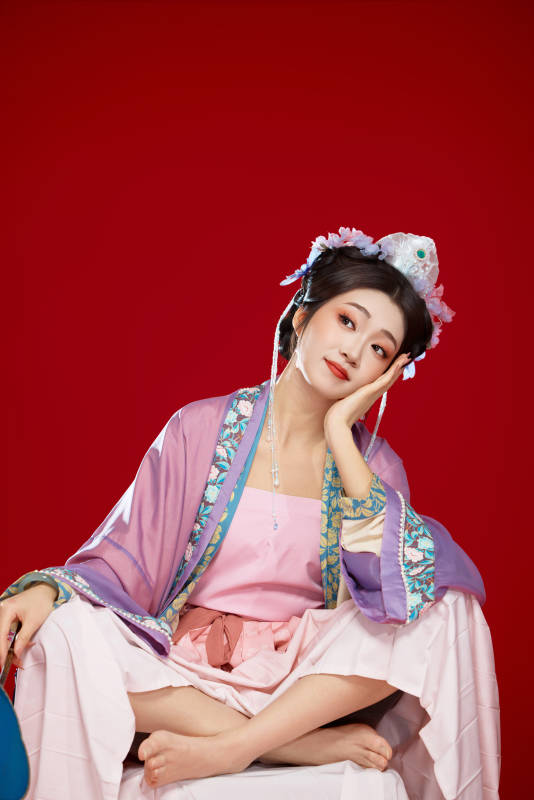 红色背景下身穿中国明朝簪花发饰汉服的美女