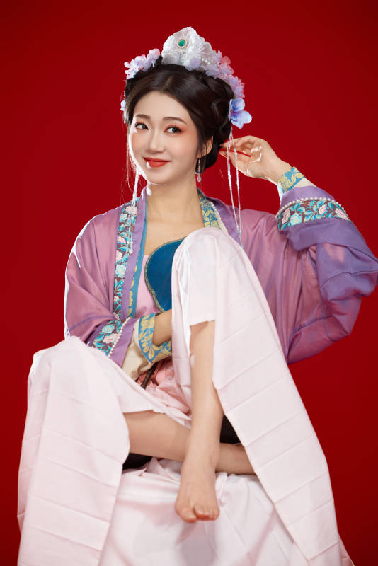 红色背景下身穿中国明朝簪花发饰汉服的美女
