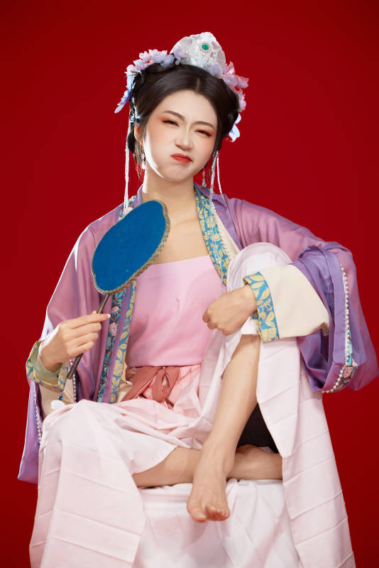 红色背景下身穿中国明朝簪花发饰汉服的美女