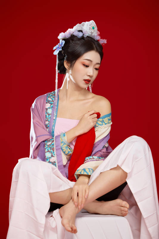 红色背景下身穿中国明朝簪花发饰汉服的美女