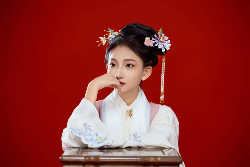 红色背景下穿着中国明朝明制汉服服饰的少女