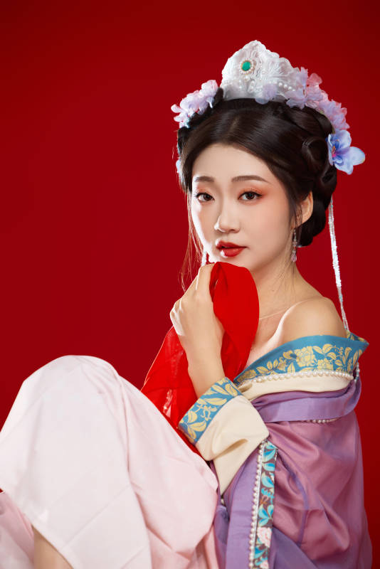 红色背景下身穿中国明朝簪花发饰汉服的美女