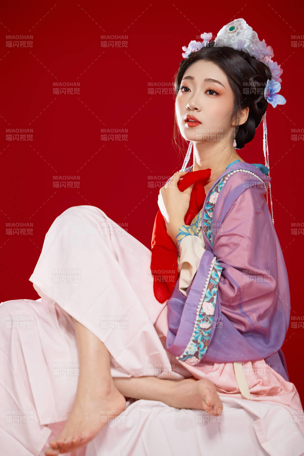 红色背景下身穿中国明朝簪花发饰汉服的美女