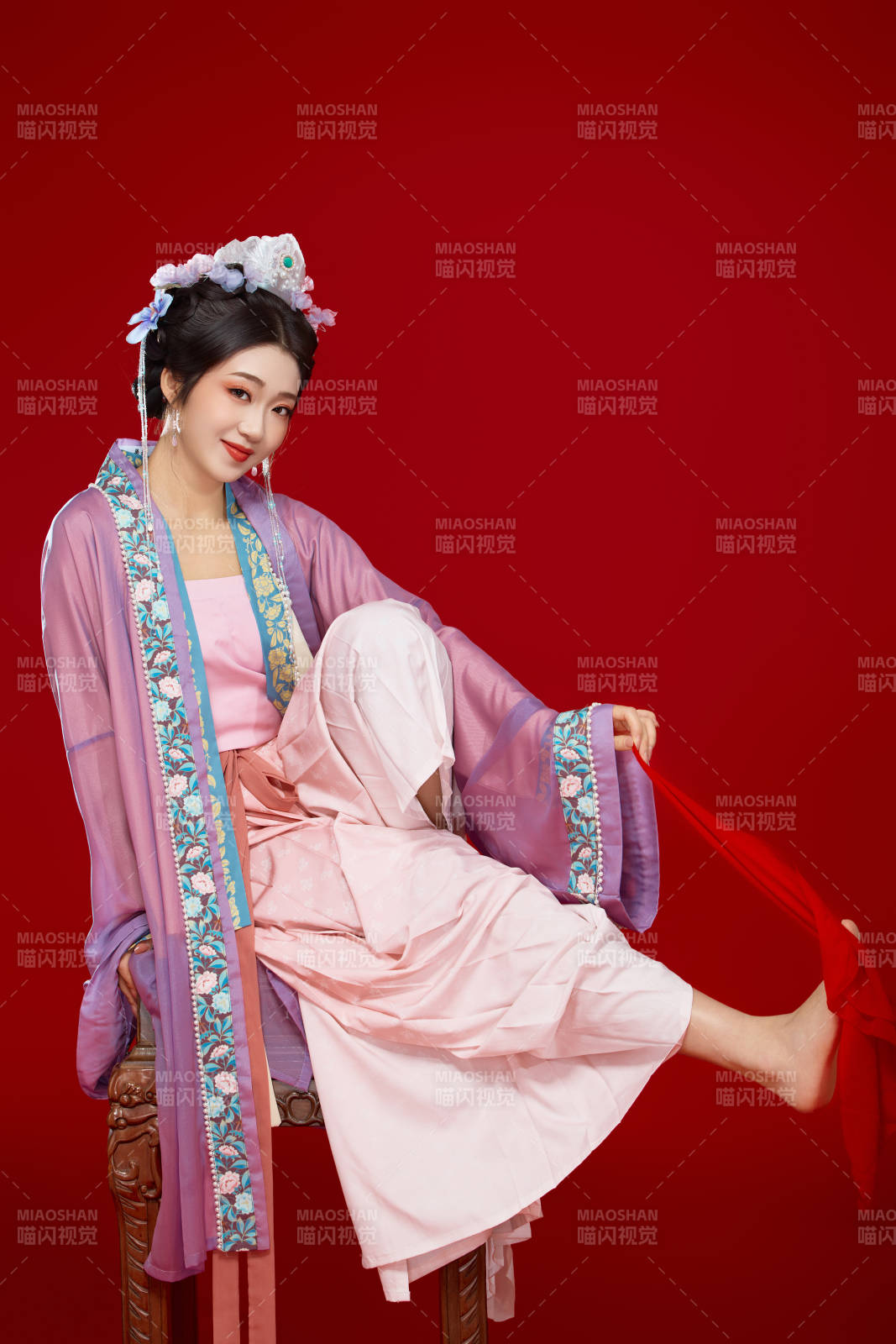 红色背景下身穿中国明朝簪花发饰汉服的美女