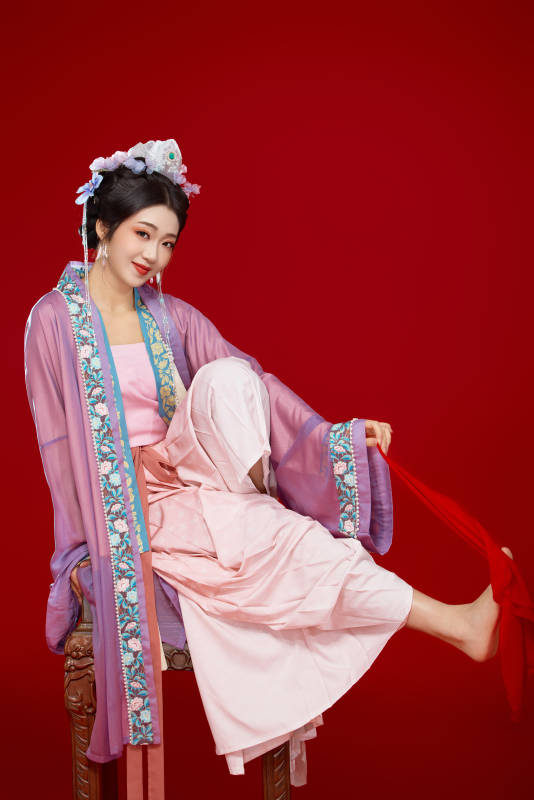 红色背景下身穿中国明朝簪花发饰汉服的美女