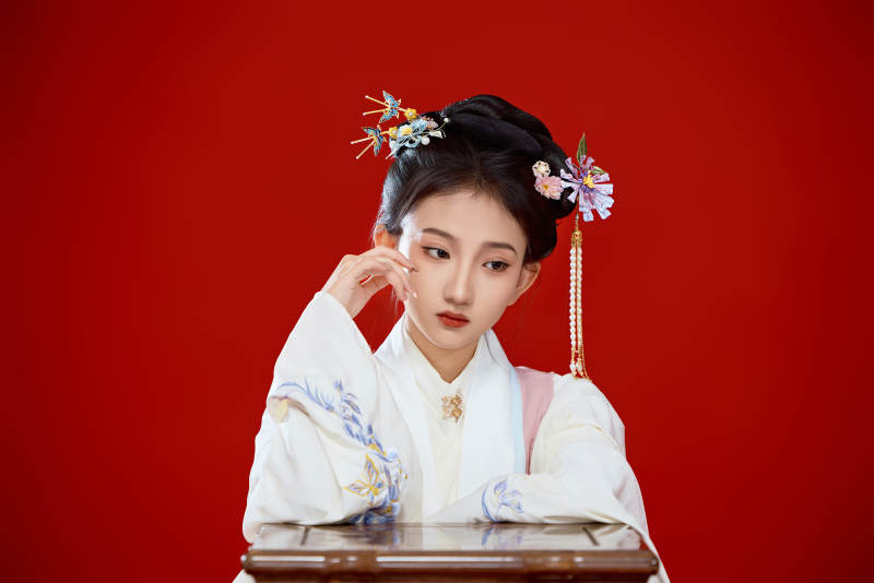 红色背景下穿着中国明朝明制汉服服饰的少女