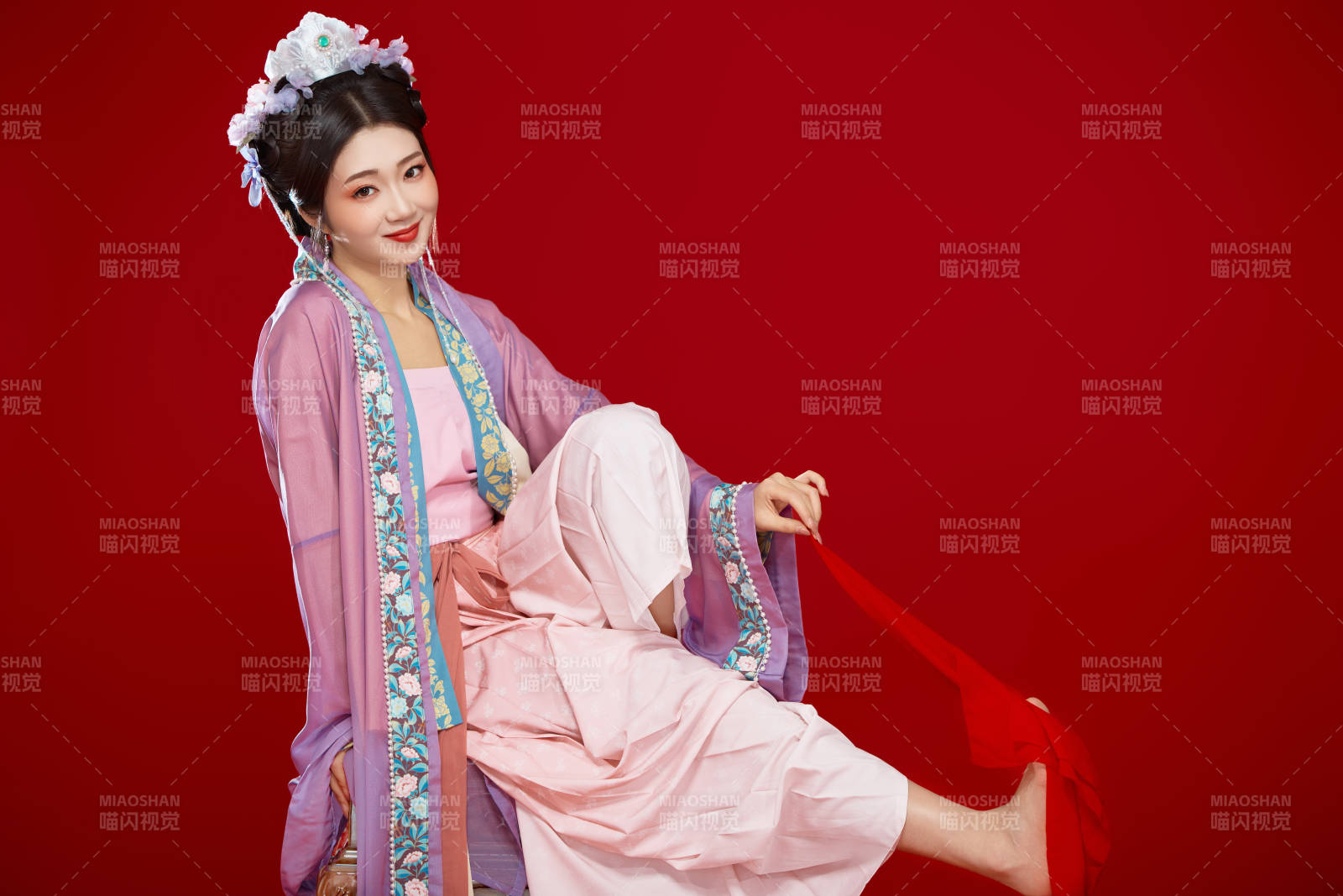 红色背景下身穿中国明朝簪花发饰汉服的美女