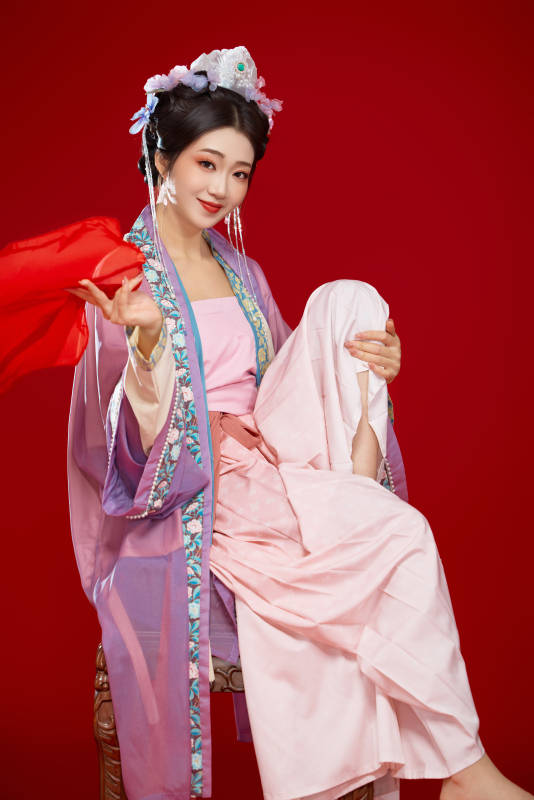 红色背景下身穿中国明朝簪花发饰汉服的美女