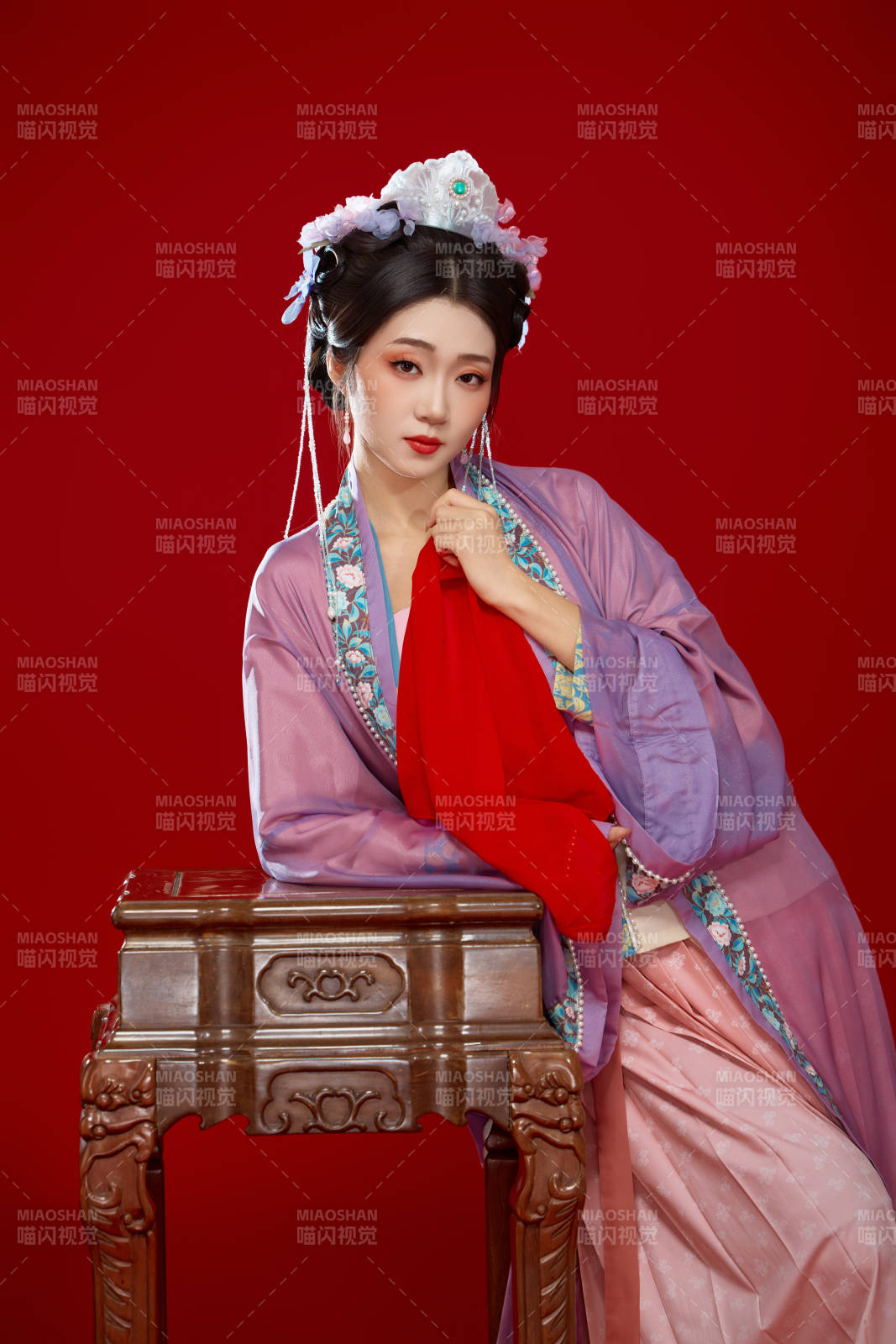 红色背景下身穿中国明朝簪花发饰汉服的美女图片