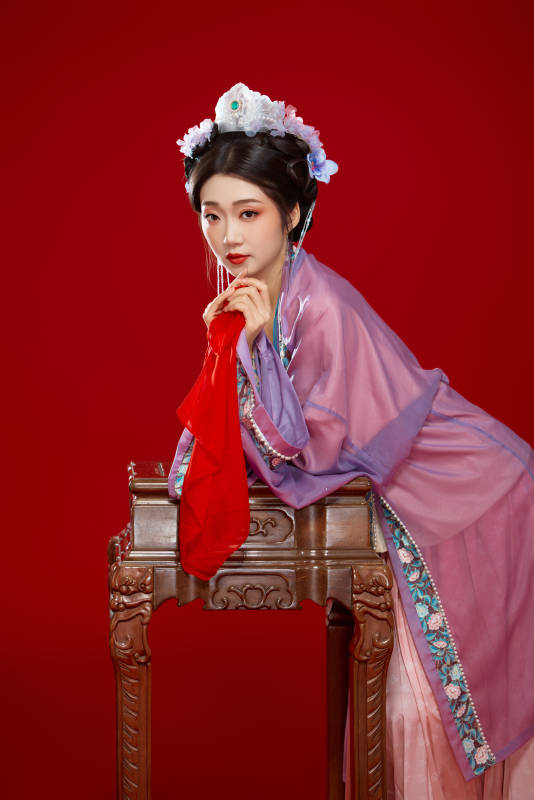 红色背景下身穿中国明朝簪花发饰汉服的美女