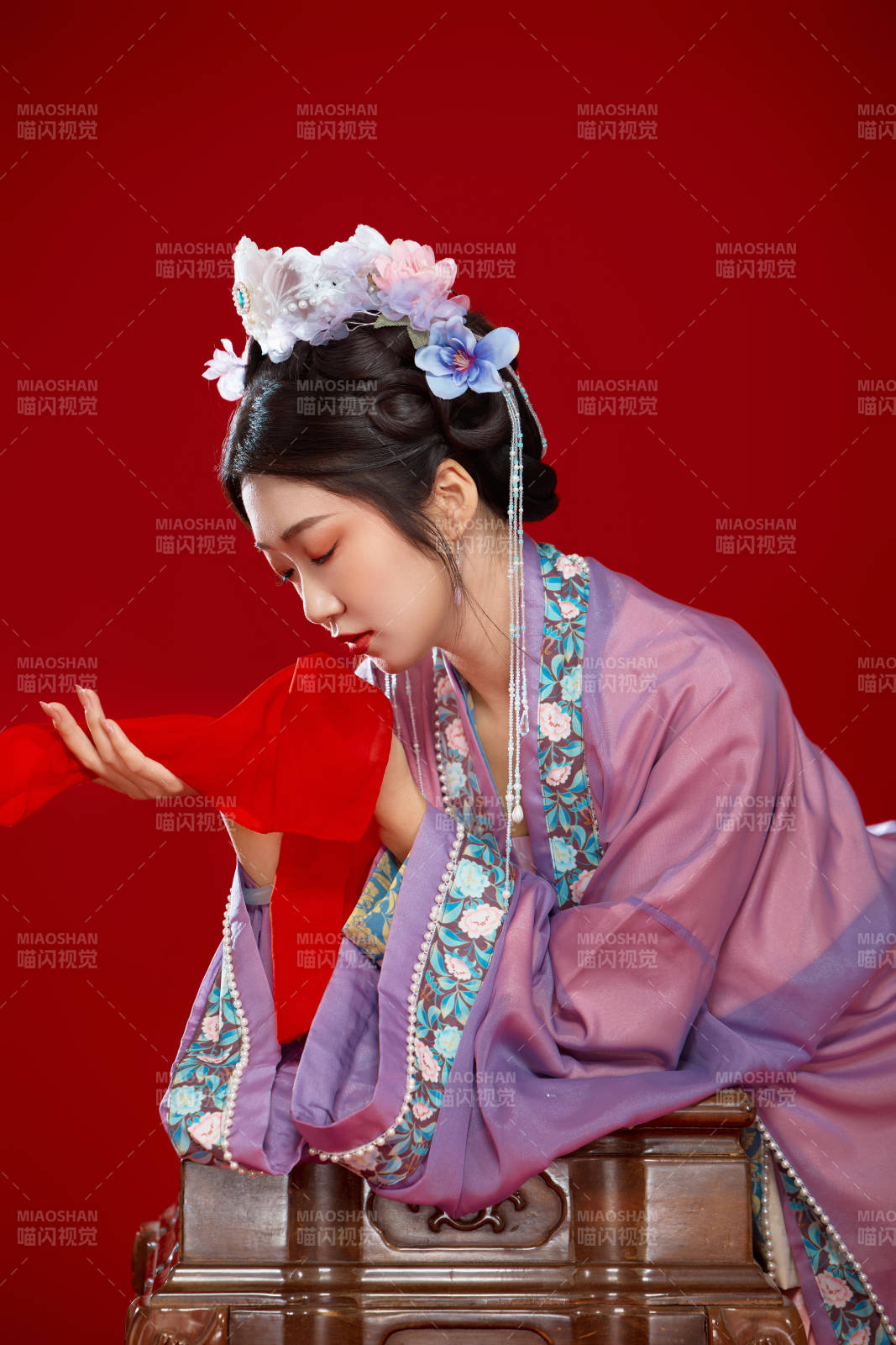 红色背景下身穿中国明朝簪花发饰汉服的美女