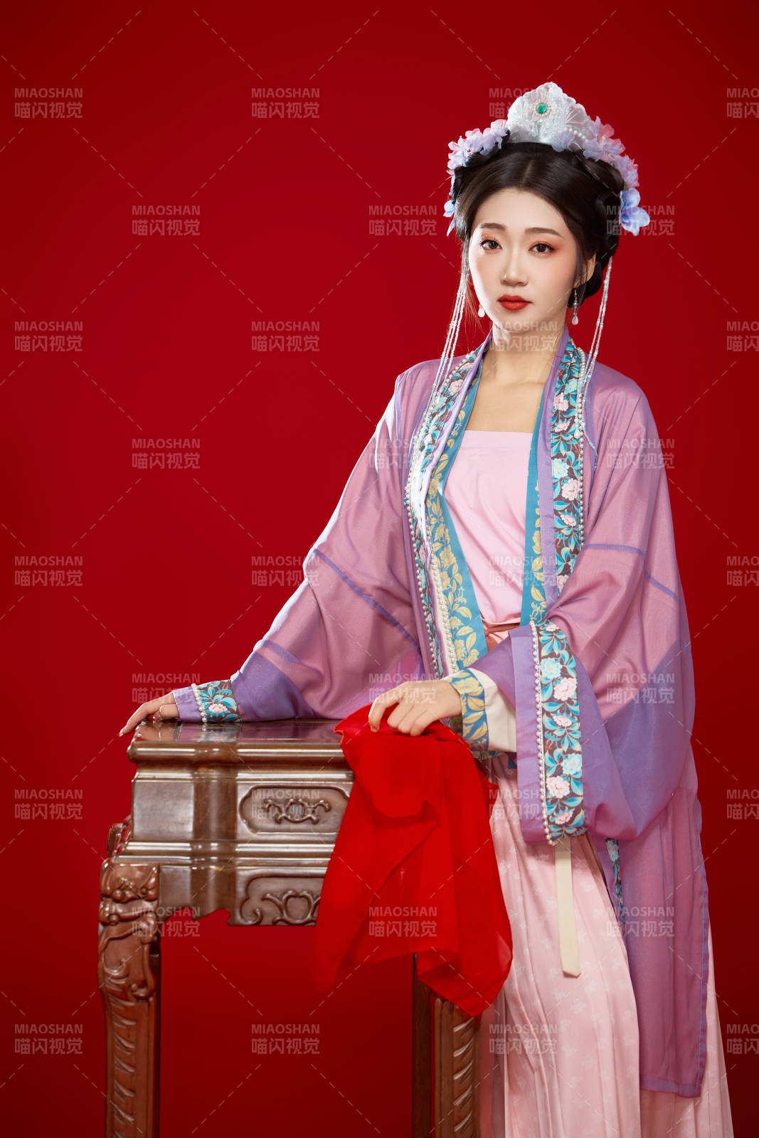 红色背景下身穿中国明朝簪花发饰汉服的美女