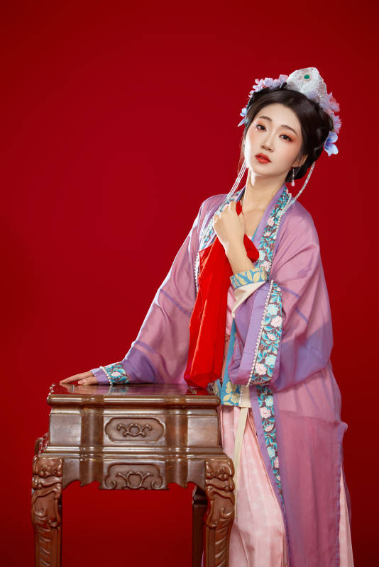 红色背景下身穿中国明朝簪花发饰汉服的美女