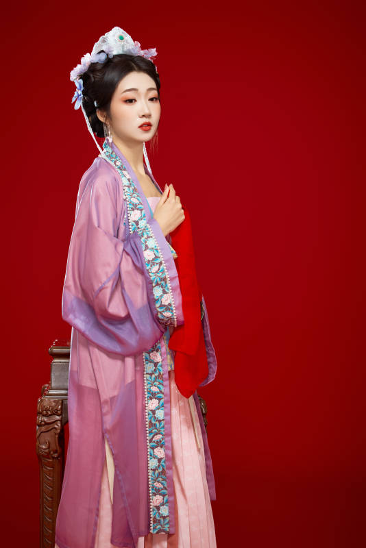 红色背景下身穿中国明朝簪花发饰汉服的美女