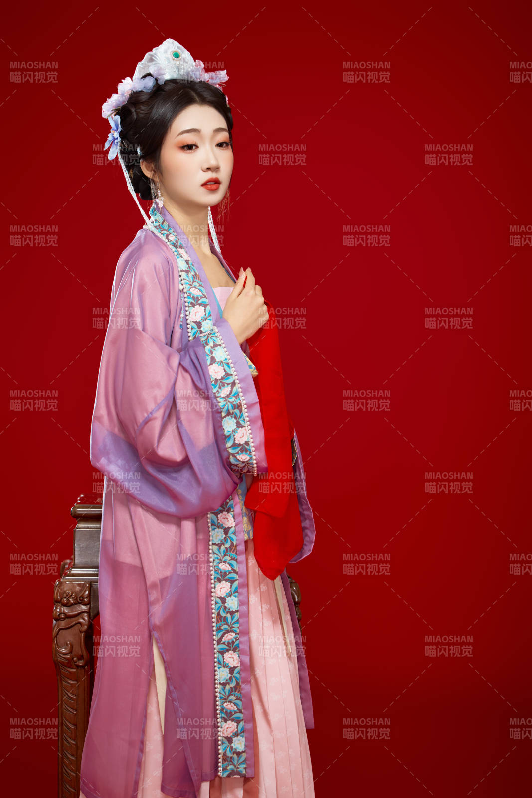 红色背景下身穿中国明朝簪花发饰汉服的美女