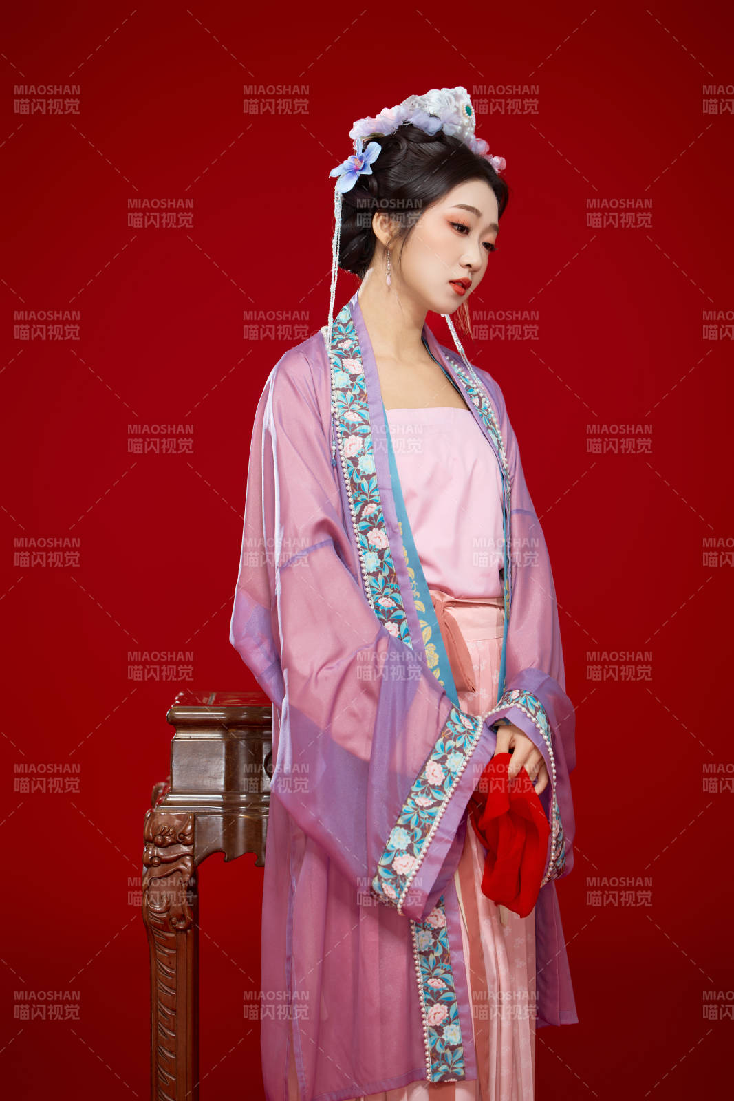 红色背景下身穿中国明朝簪花发饰汉服的美女