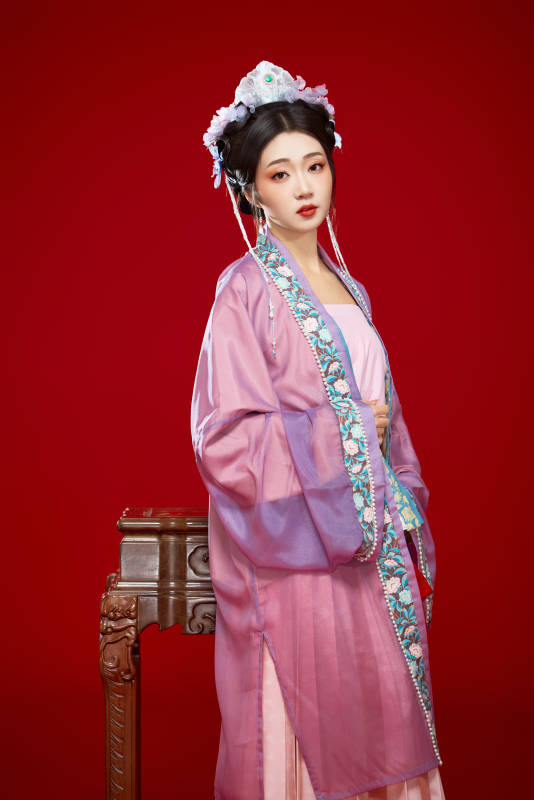 红色背景下身穿中国明朝簪花发饰汉服的美女