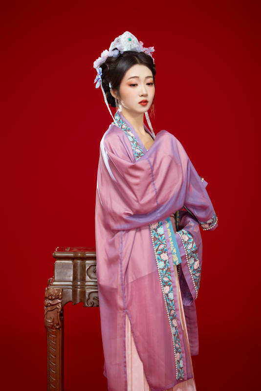 红色背景下身穿中国明朝簪花发饰汉服的美女