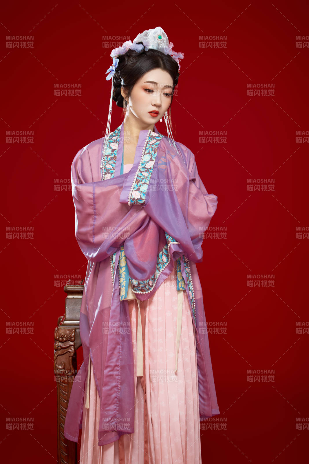 红色背景下身穿中国明朝簪花发饰汉服的美女