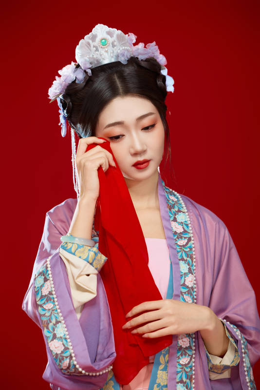 红色背景下身穿中国明朝簪花发饰汉服的美女