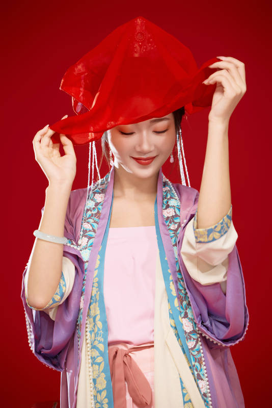 红色背景下身穿中国明朝簪花发饰汉服的美女