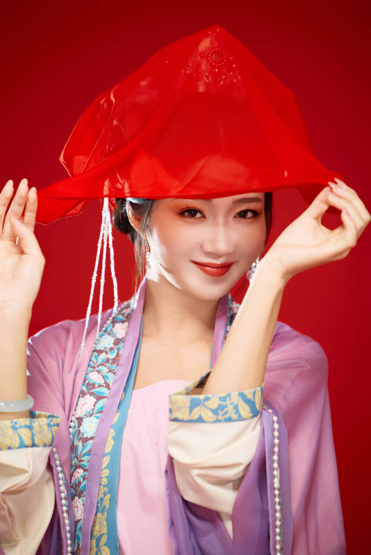 红色背景下身穿中国明朝簪花发饰汉服的美女