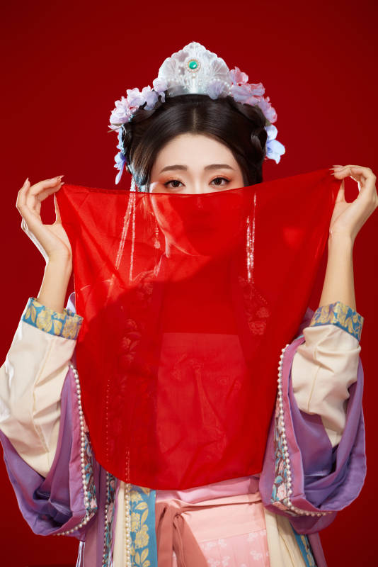 红色背景下身穿中国明朝簪花发饰汉服的美女