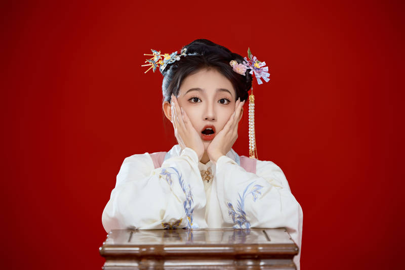 红色背景下穿着中国明朝明制汉服服饰的少女