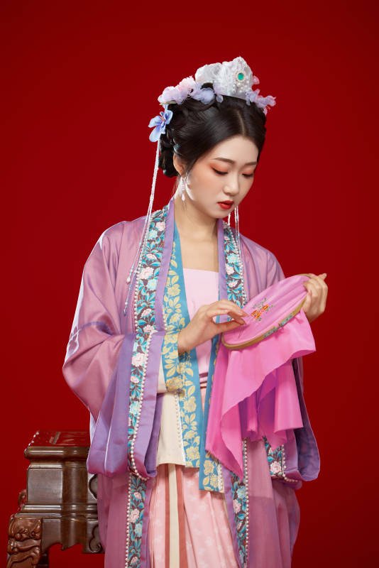红色背景下身穿中国明朝簪花发饰汉服的美女