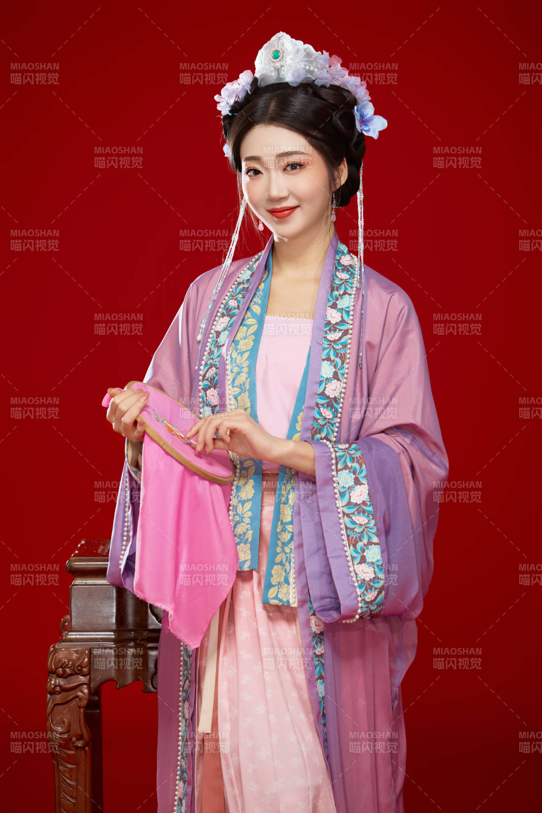 红色背景下身穿中国明朝簪花发饰汉服的美女